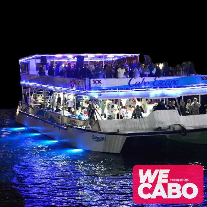 Imagen de un catamarán navegando al atardecer en Cabo San Lucas, con vistas al Arco y Playa del Amor, mientras los pasajeros disfrutan de una cena buffet de fajitas y entretenimiento.