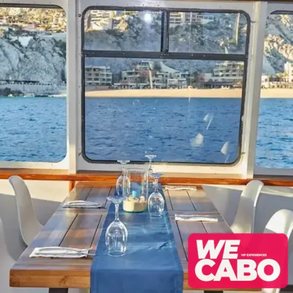 Imagen de un crucero al atardecer en Cabo San Lucas, con vistas al Arco y Playa del Amor, mientras los pasajeros disfrutan de una cena, música en vivo y barra libre.