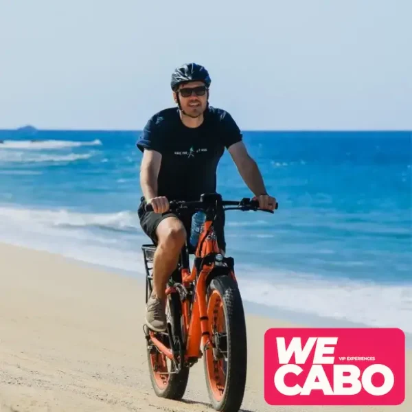 Image of a dual-motor electric bike on an off-road trail in Los Cabos, surrounded by desert scenery and clear blue skies.