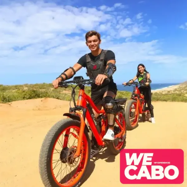 Image of a dual-motor electric bike on an off-road trail in Los Cabos, surrounded by desert scenery and clear blue skies.