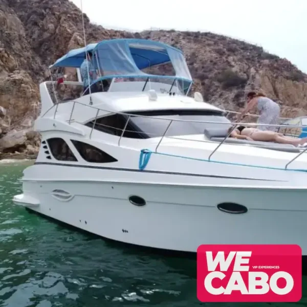 Image of a 42ft Silverton yacht cruising through the crystal-clear waters of Los Cabos, featuring an open bar, paddleboard, and snorkeling gear for a luxurious day at sea.