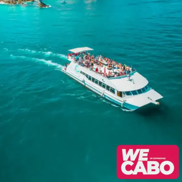 Image of a sunset dinner cruise in Cabo San Lucas, featuring views of The Arch and Lover’s Beach, with guests enjoying dinner, live music, and an open bar.