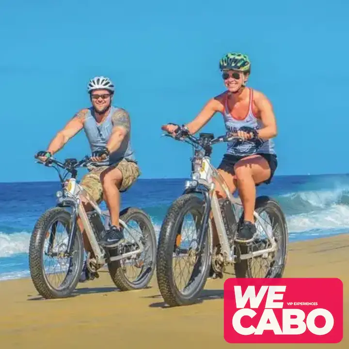 Imagen de una bicicleta eléctrica de doble motor recorriendo un sendero todoterreno en Los Cabos, rodeada de un paisaje desértico y cielos despejados.