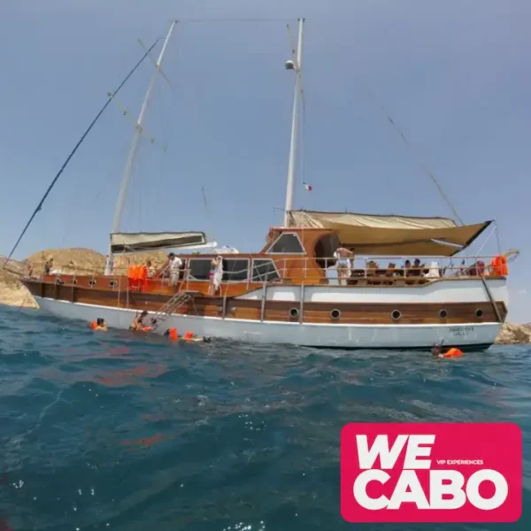 Imagen de un yate de lujo navegando al atardecer en Cabo San Lucas, con cena de chef privado y barra premium, cortesía de WECABO.